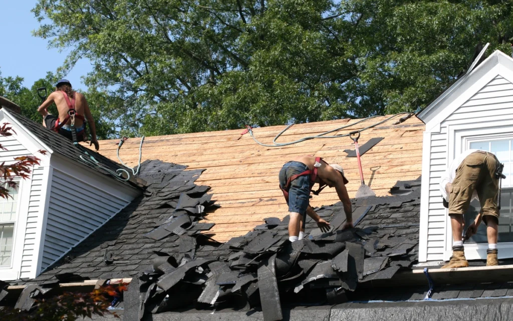roofing contractors tear off existing roof before laying new one