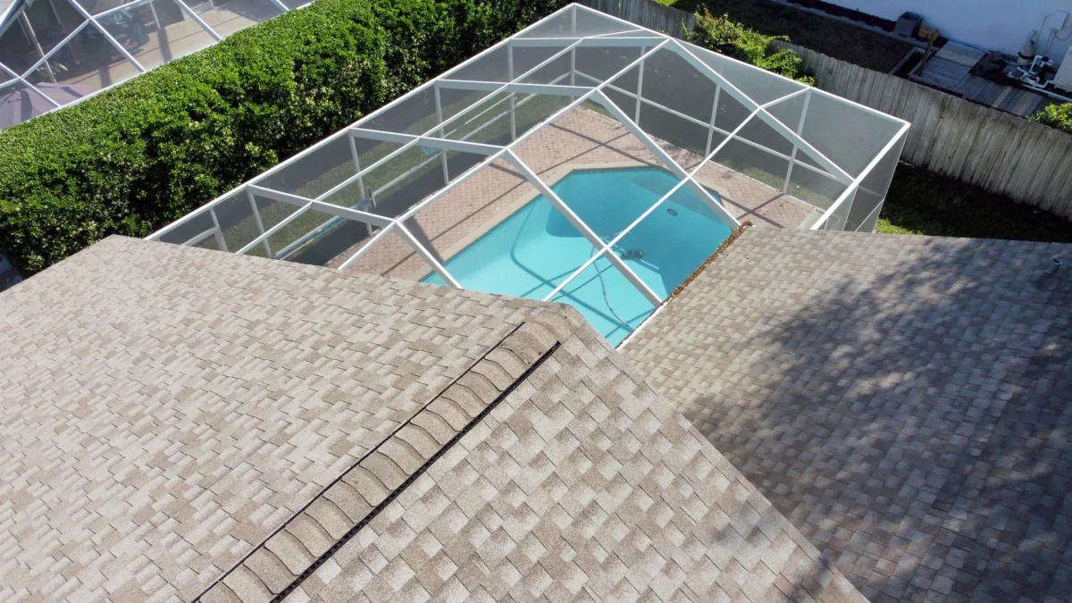 drone aerial view of florida shingle roof with caged in pool