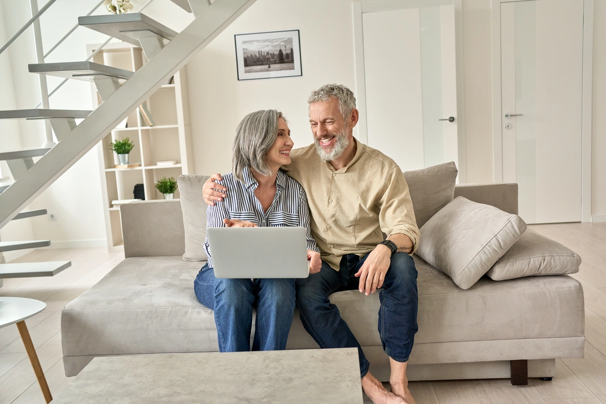 happy couple at home researching avenue roofing replacements
