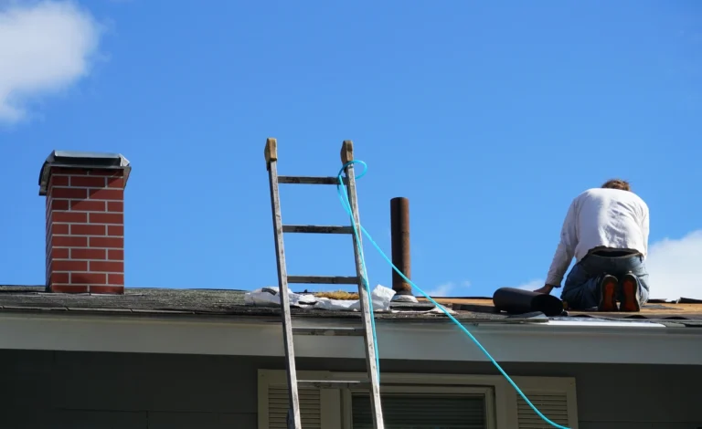 contractor using tools to replace roof works with shingles