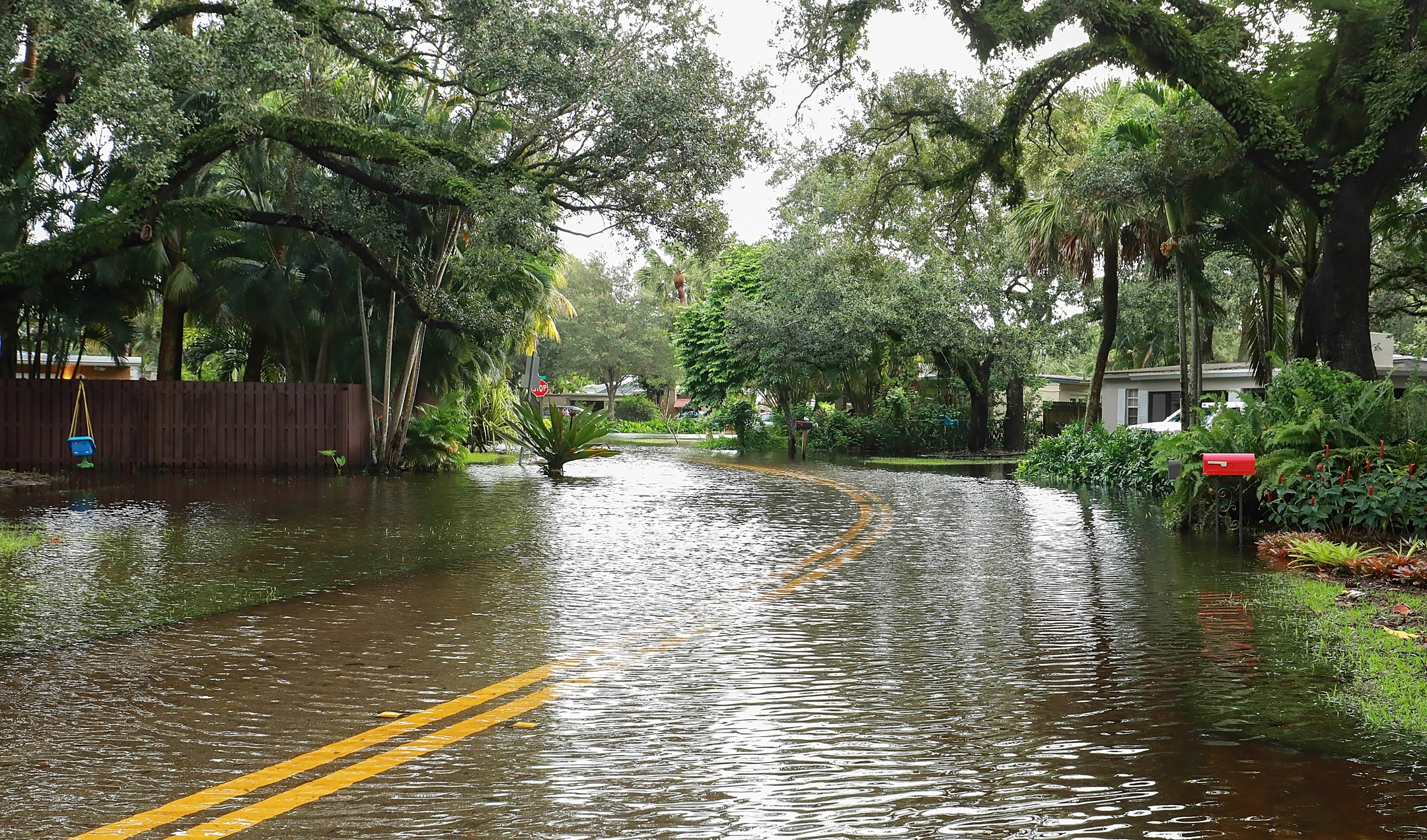 flooded Florida street in Jacksonville with houses needing storm restoration