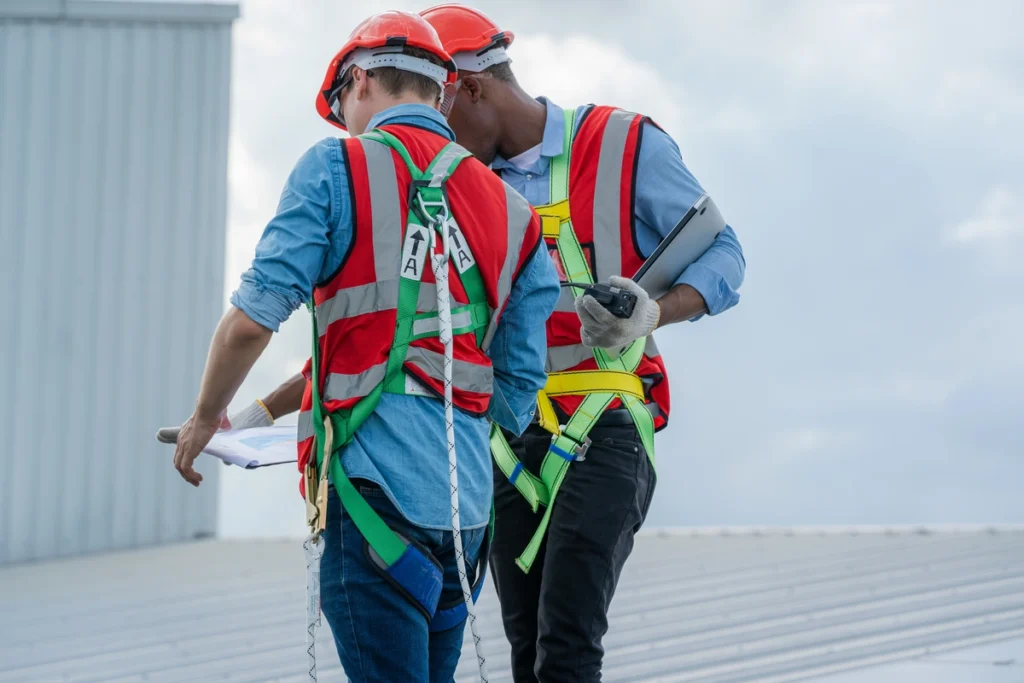 professional workers inspecting the roof wearing safety belt 