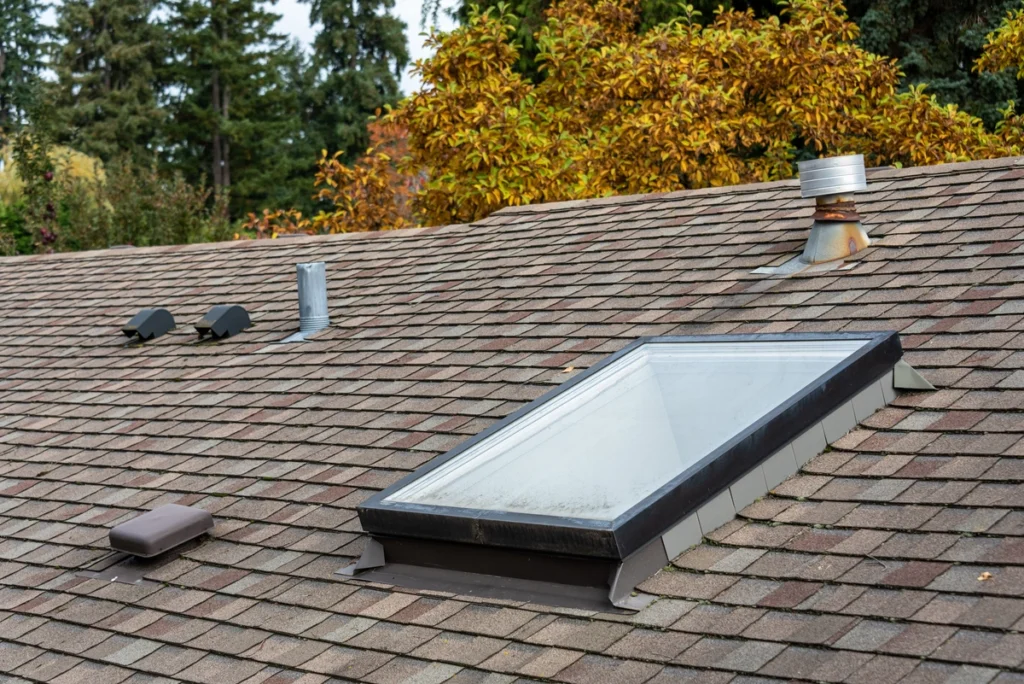 a collection of roof vents surrounding a skylight