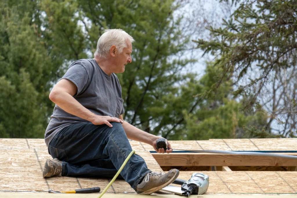 older man measures a roof