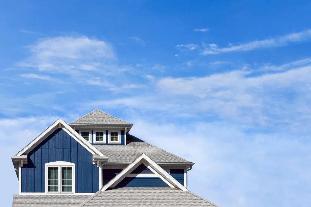 beautiful blue home against clear sky with composite shingles