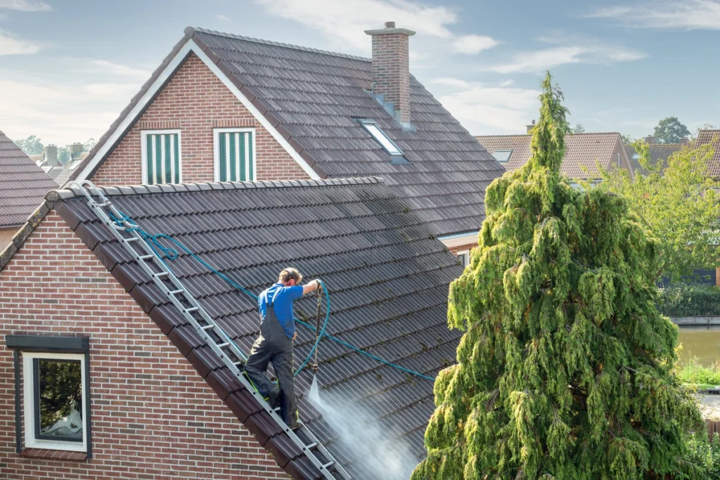 roofer applying a roof coating on a pitched shingled roof