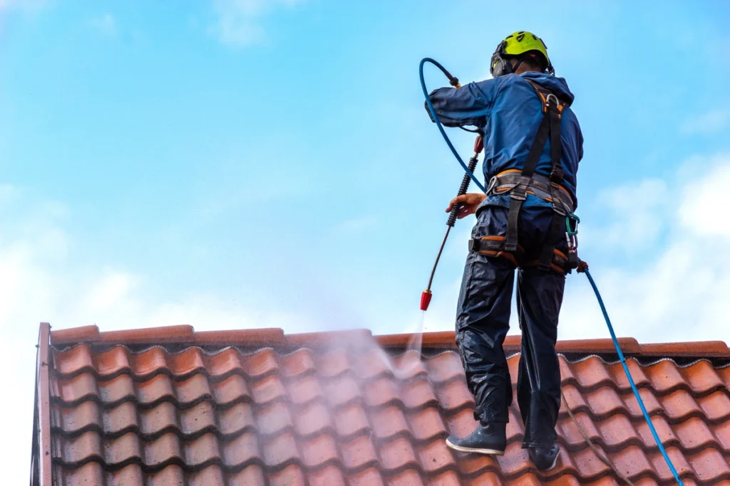 roofer applying a roof coating to a terracotta roof